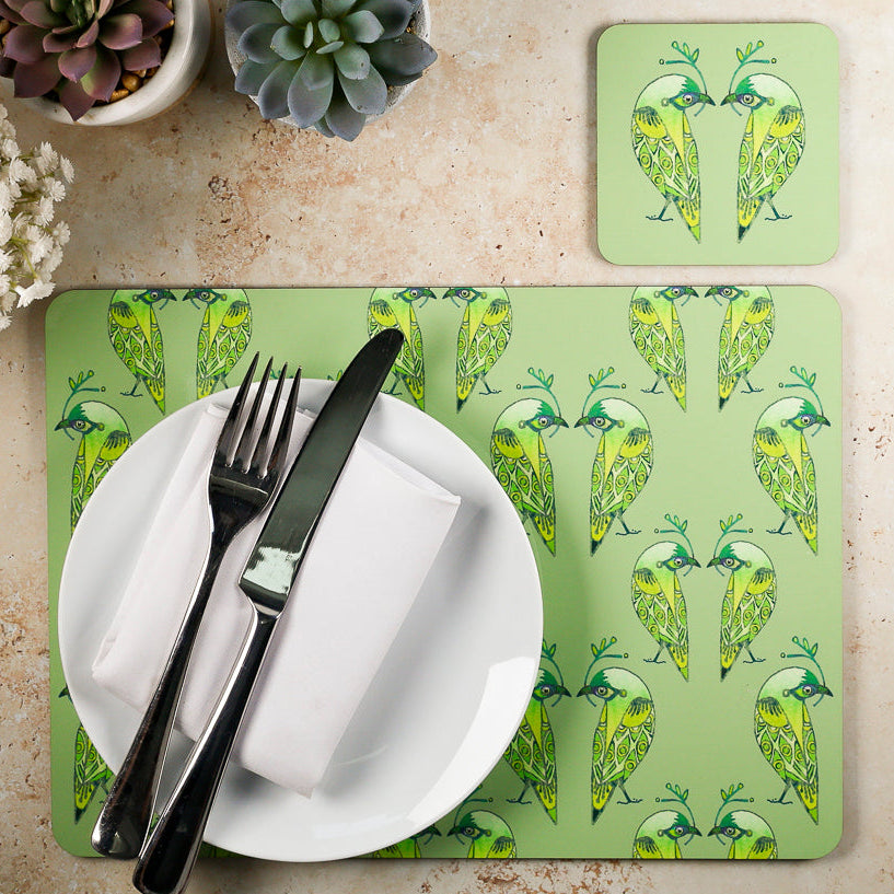 Placemat with bird pattern on a table setting with cutlery and plate.