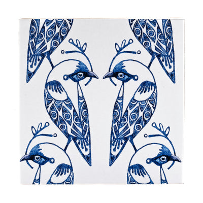 Decorative tile with blue and white bird design on a white background