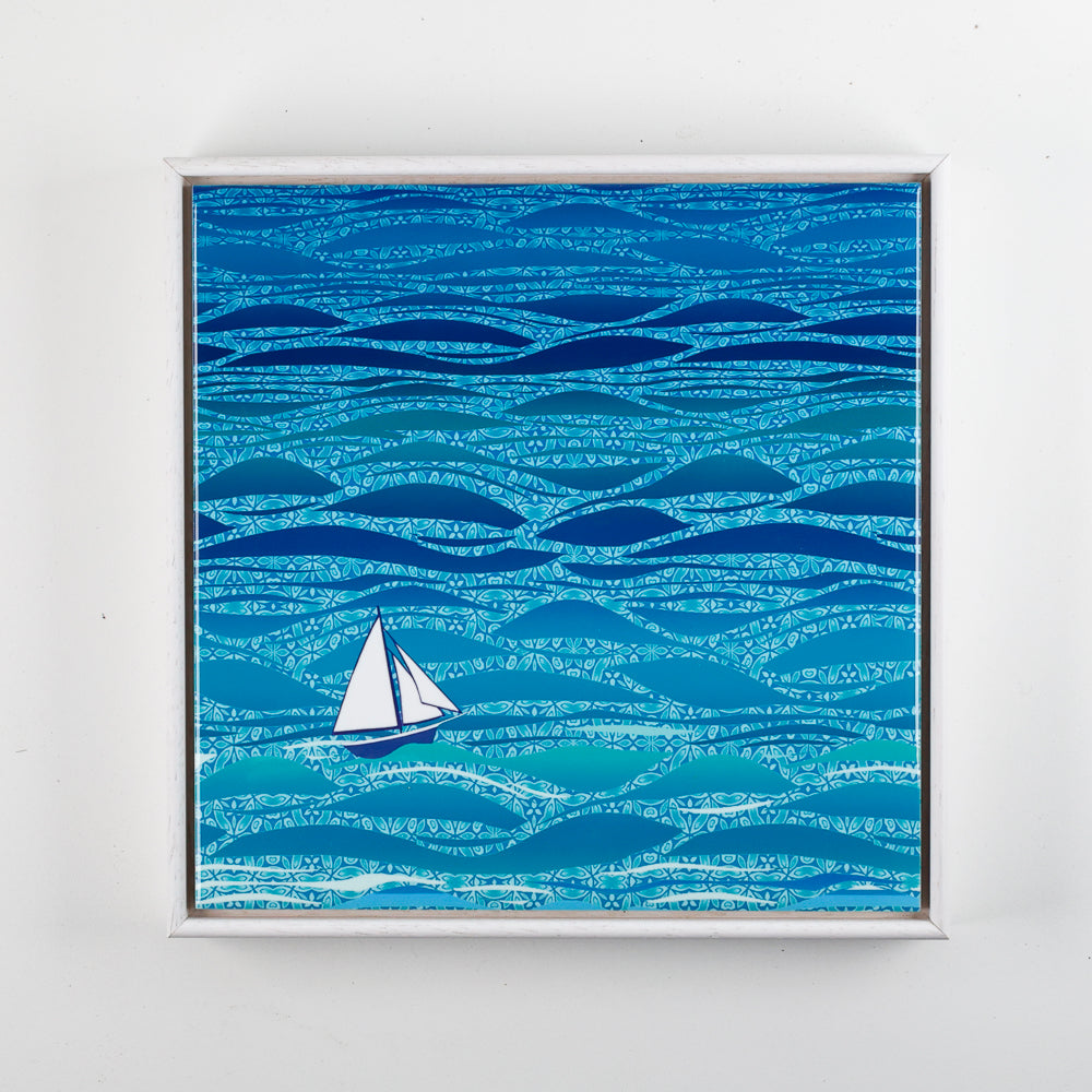 Framed artwork with a sailboat on a blue wave pattern